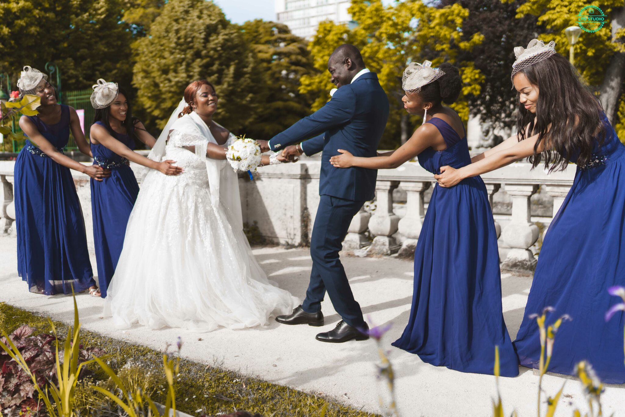 Cortège en robes bleues entourant la mariée devant un château