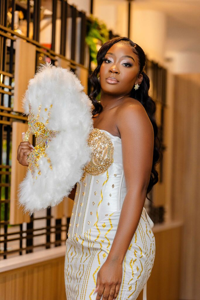 Mariée en tenue traditionnelle tenant un éventail en plumes